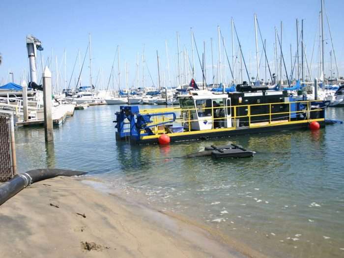 An contractor performs maintenance dredging at a major sailing center in San Diego, California.