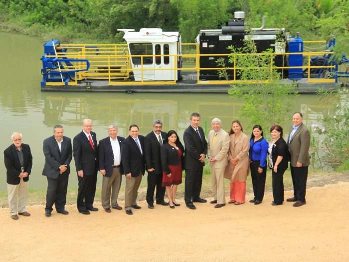 The Brownsville Public Utility Board (PUB) standing in front of one of two IMS 5012 HP Versi-Dredge units they use to clear their inner connected chain of lakes called “resacas”.